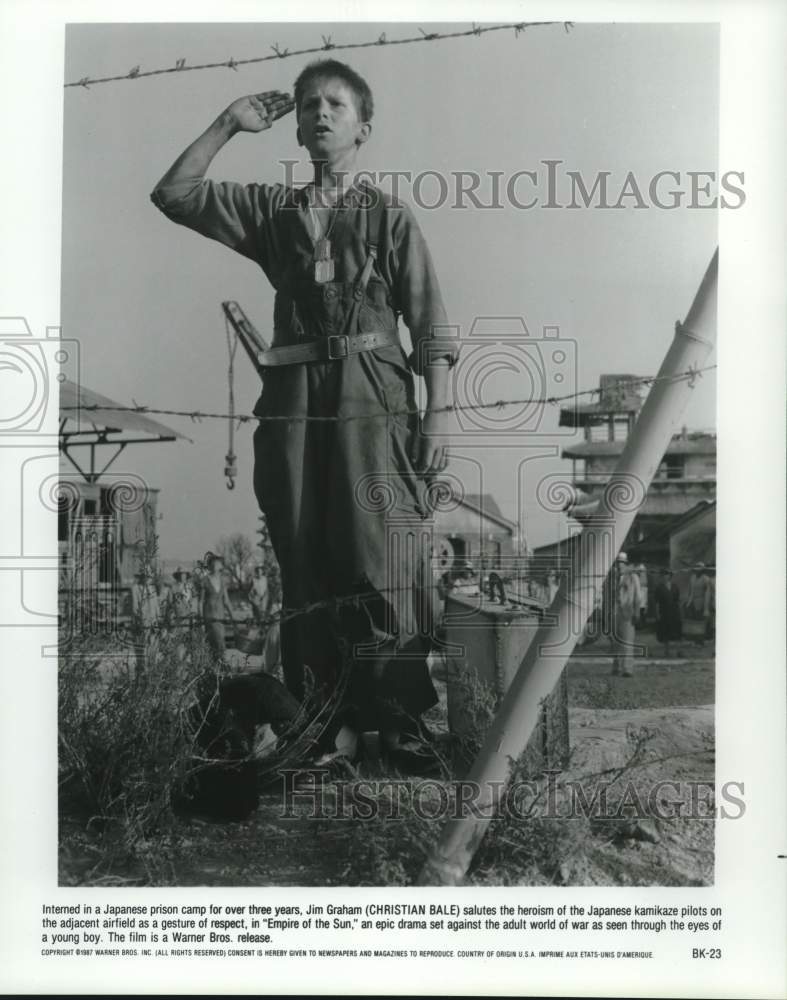 1987 Press Photo Christian Bale salutes Japanese pilots in &quot;Empire of the Sun&quot; - Historic Images