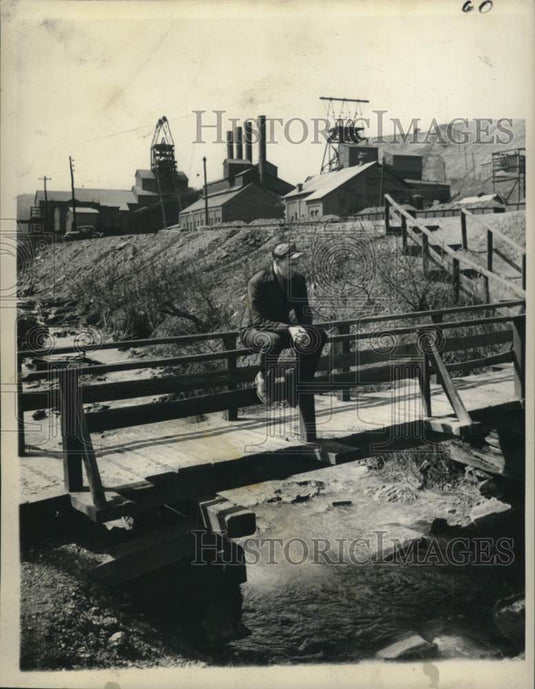 1946 Press Photo Striking coal miner sits on creek bridge in Pennsylvania.- Historic Images