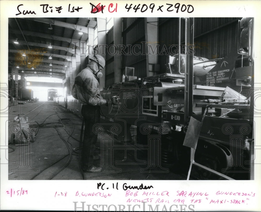 1989 Press Photo Gunderson Inc employee Bob Miller spray paints stack car - Historic Images