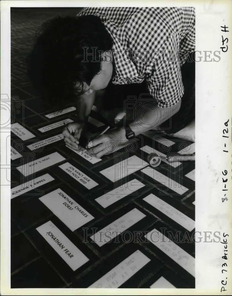 1986 Press Photo Rogelio Salazar etches names on bricks for Pioneer Square - Historic Images