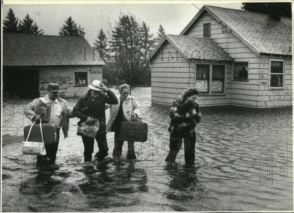 1982 Press Photo Family evacuates from Astoria home after a widespread flooding- Historic Images