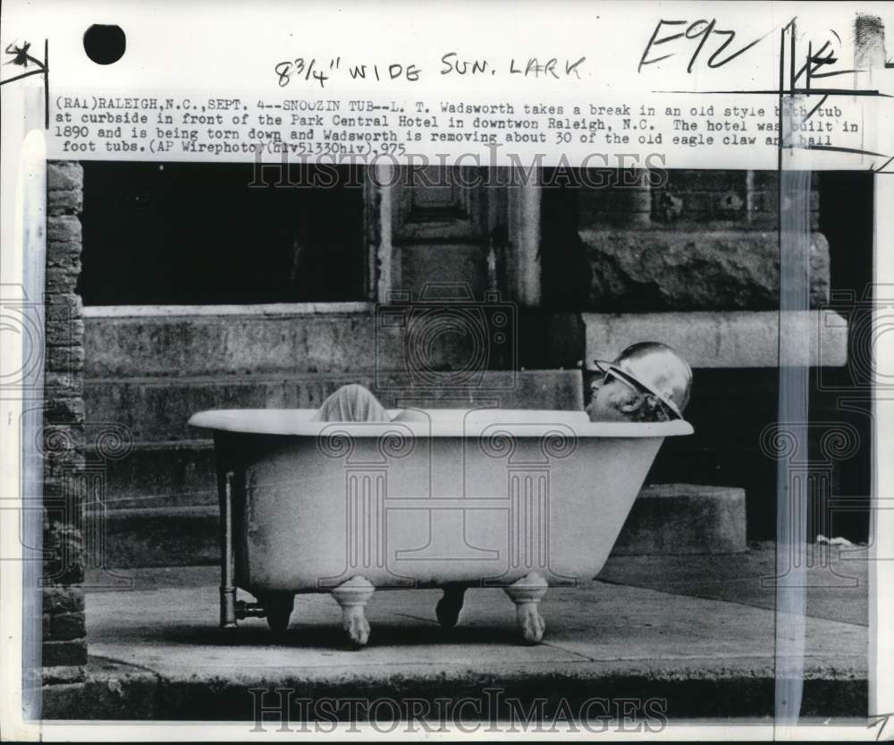 1975 Press Photo L. Wadsworth naps in a bathtub at a hotel demolition site in NC - Historic Images