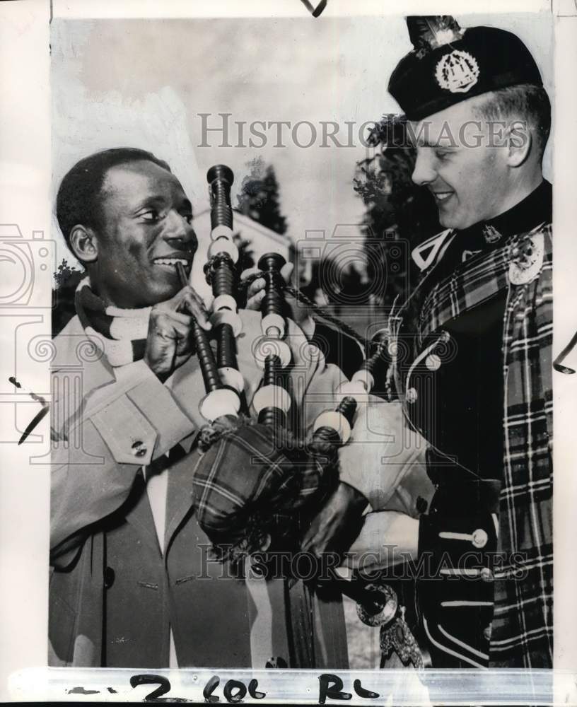 1954 Press Photo G.S. Laryea checks Andy Perrie&#39;s bagpipes, British Empire Games- Historic Images