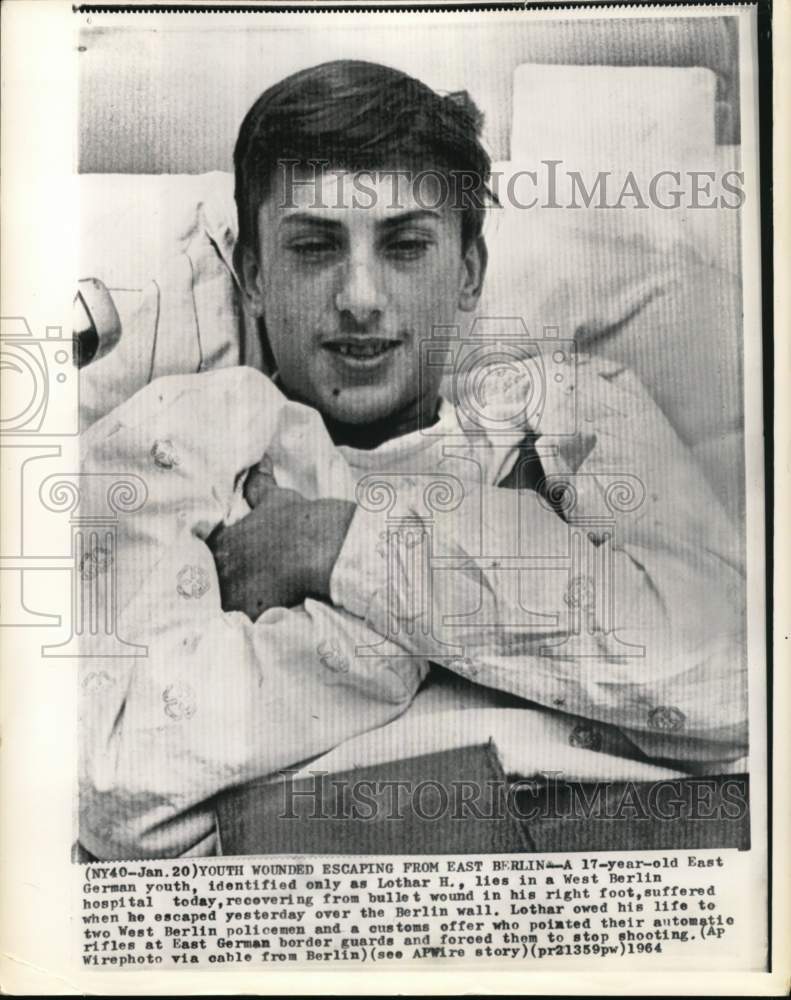 1964 Young man wounded from escaping lies in hospital bed-Historic Images