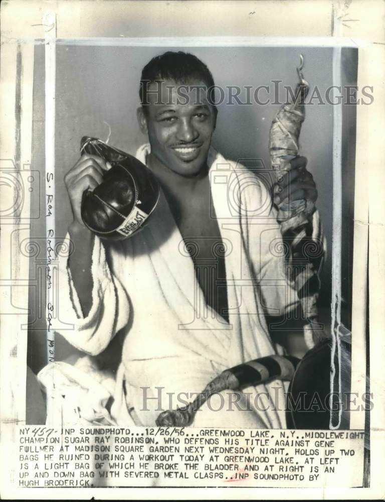 1956 Press Photo Sugar Ray holds up two bags he ruined on a workout, New York - Historic Images