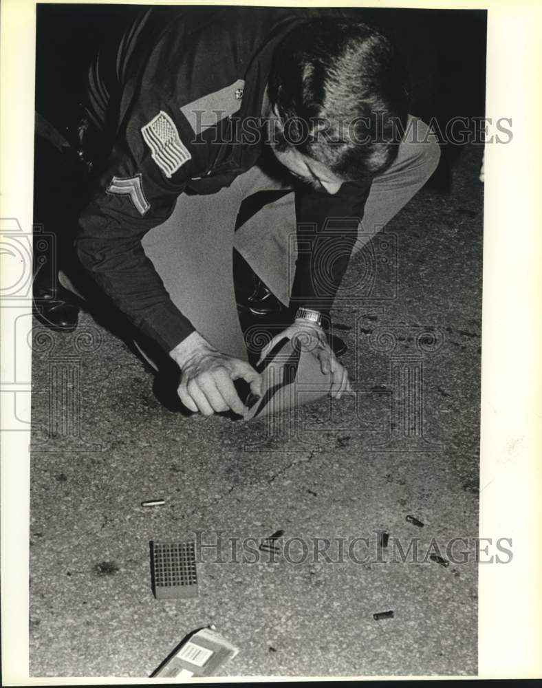 Press Photo Police detective Fred Balmos picks up spent shell casings - Historic Images