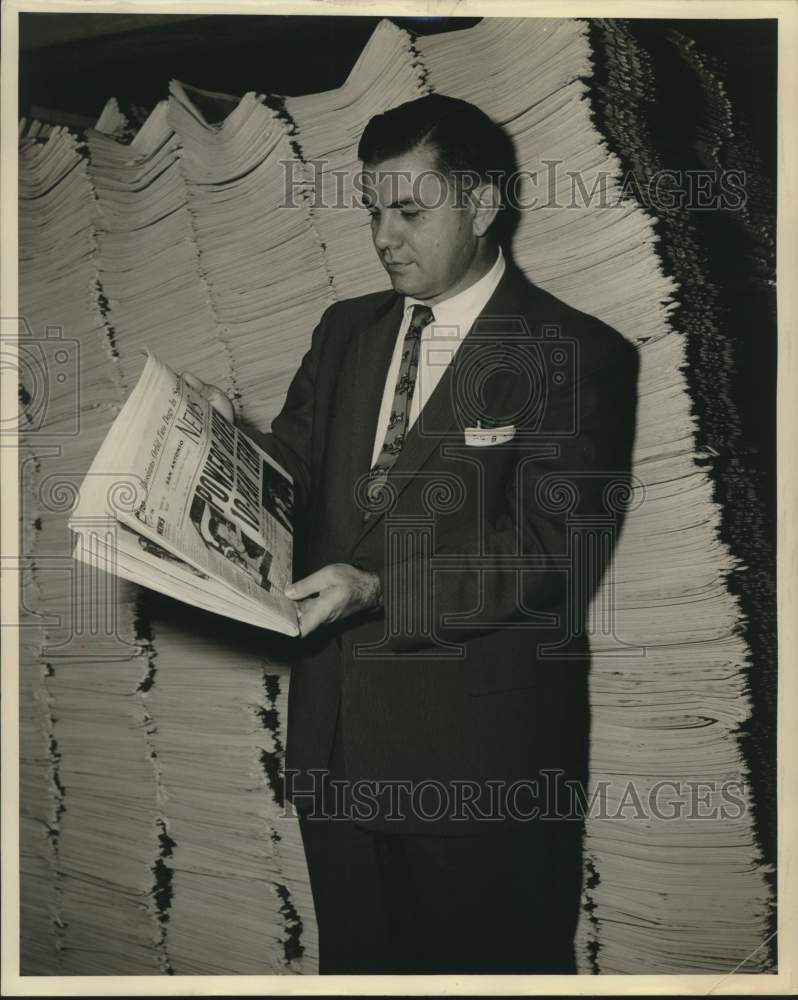 Press Photo Bill Bellamy standing in front of stacks of newspapers, Texas - Historic Images