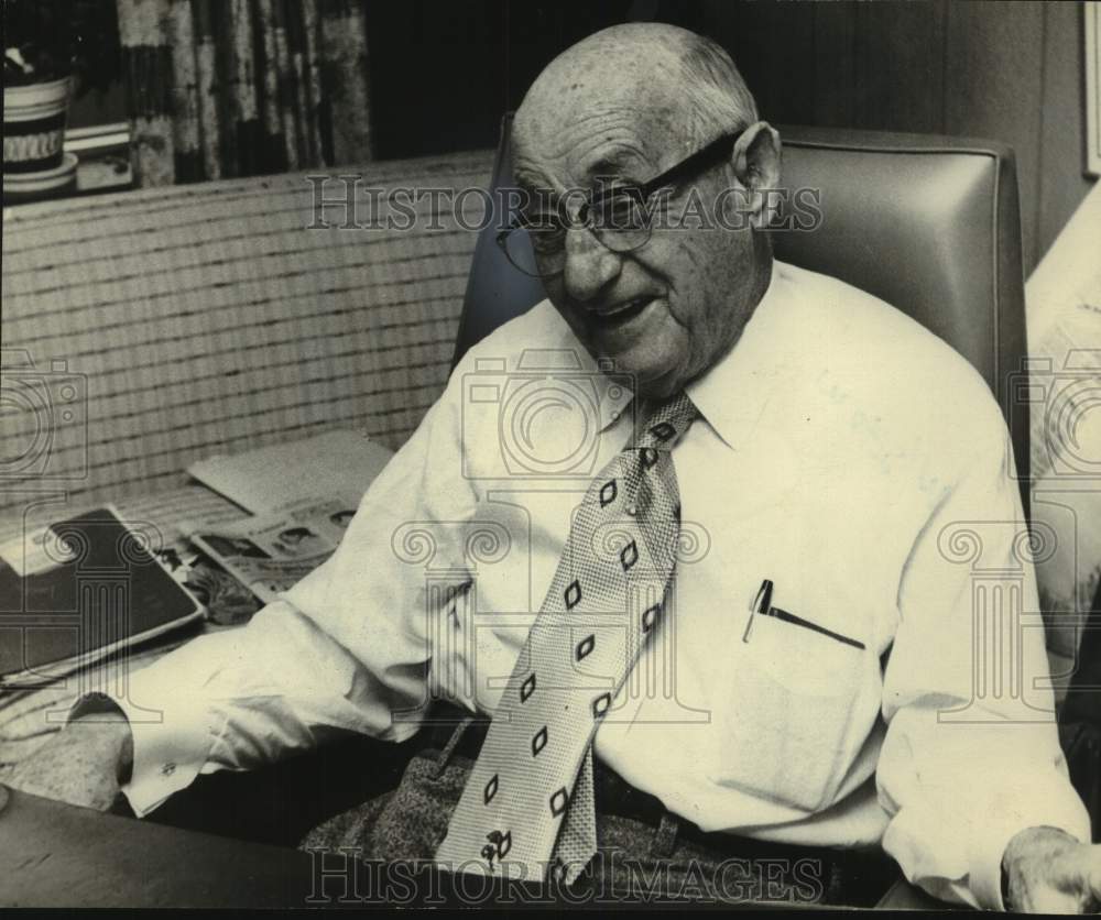 Harry Freeman of ABC seated at desk smiling - Historic Images