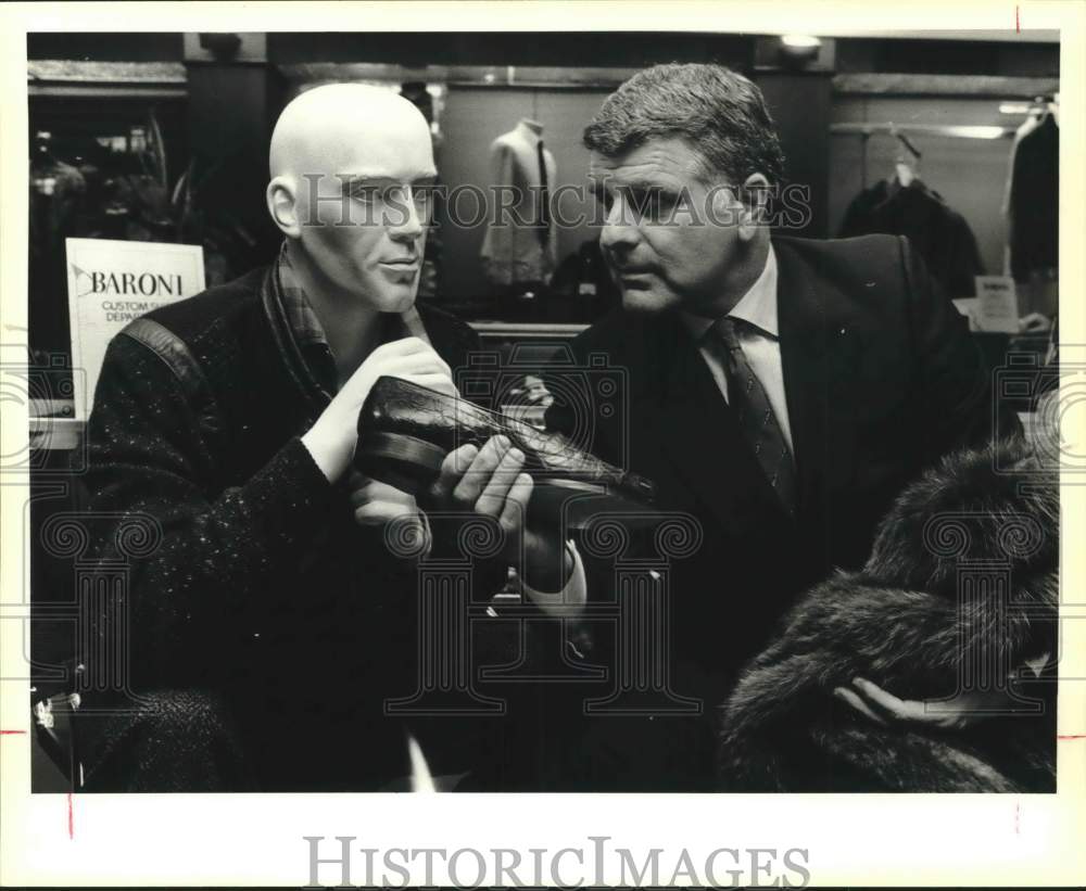 1986 Phil Romano, CEO of Fuddrucker&#39;s, showing shoe to a mannequin - Historic Images