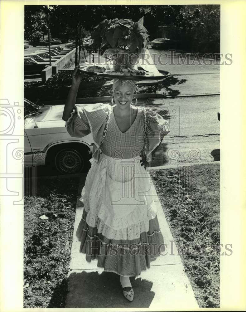 1985 Saundra Henderson carries tray of food on her head, Texas-Historic Images