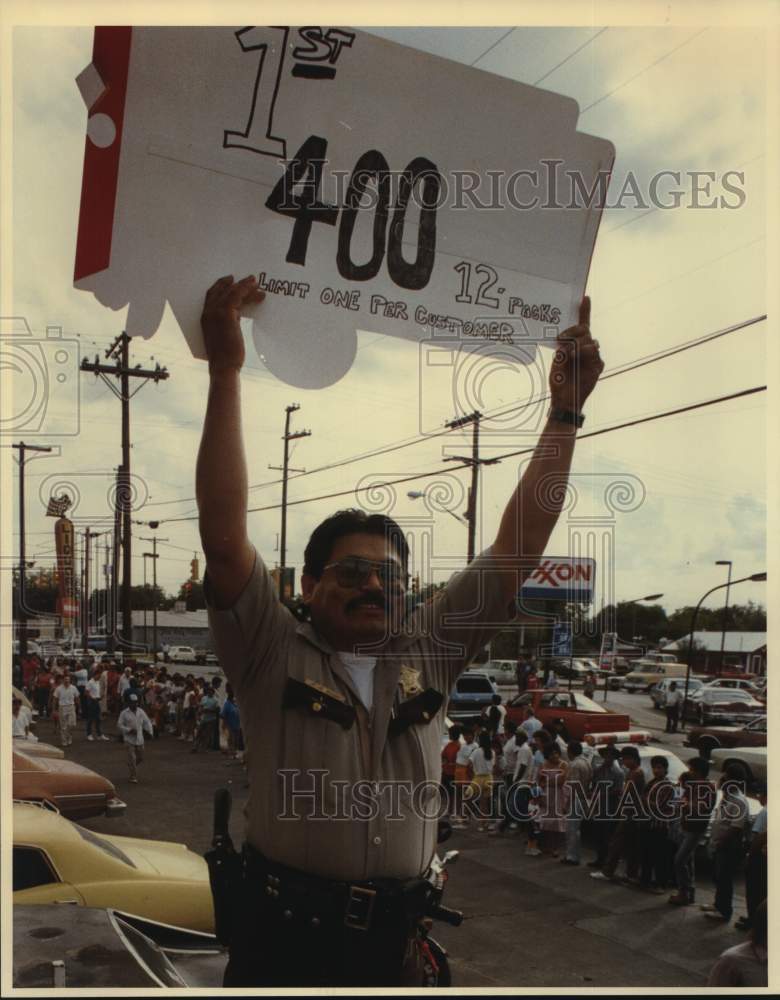 1987 Security guard at Gabriel's Liquor Store holds sign for sale-Historic Images