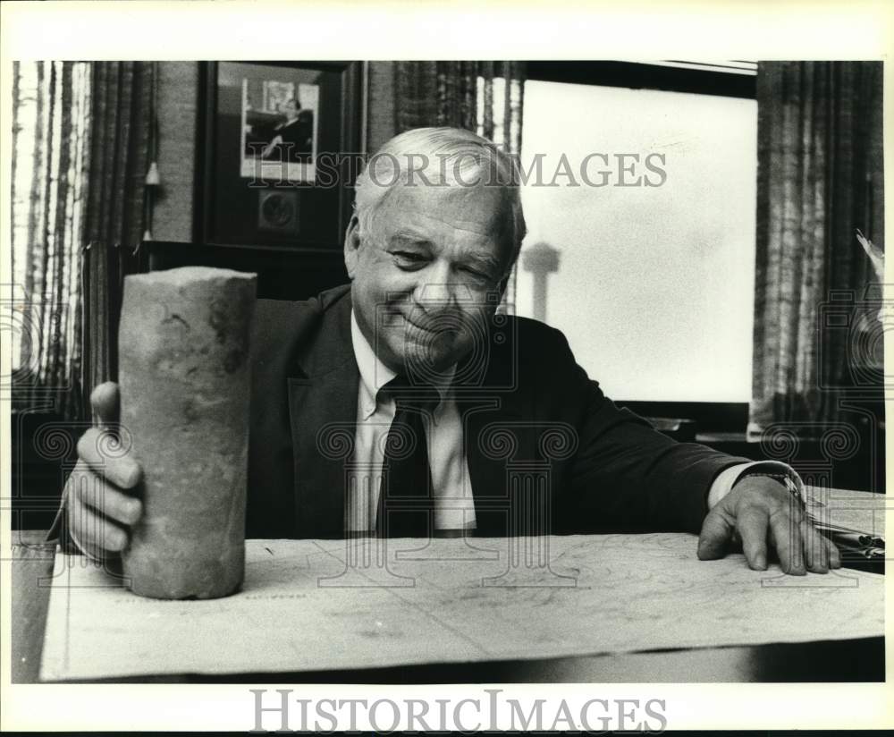 1987 Geologist M.O. Turner with rock core in his office-Historic Images