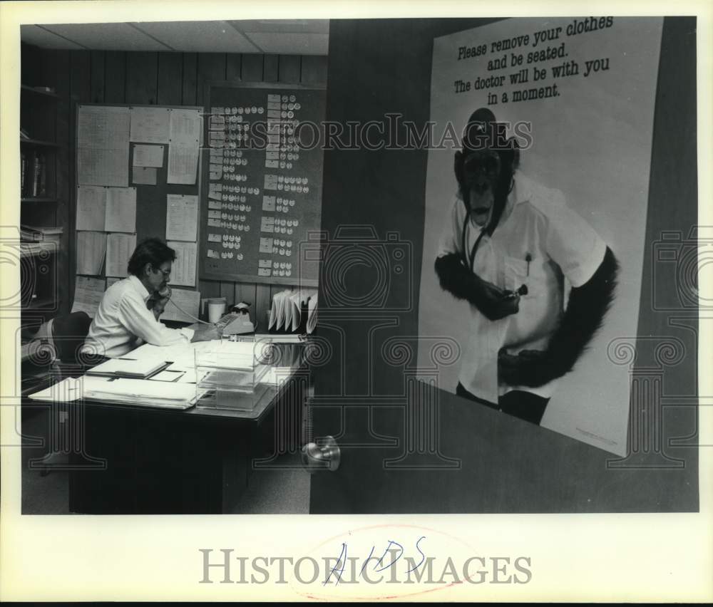 Gentleman on phone at desk works on AIDs research, Texas-Historic Images