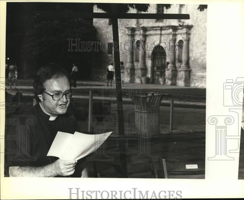 1983 Father Balty Tanacek, Alamo Plaza mission, reads paper-Historic Images