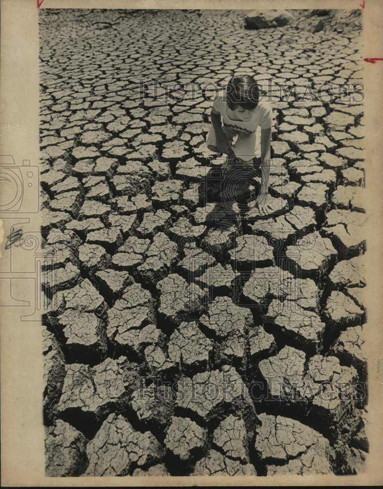 1978 Lawna Garcia investigates San Antonio River bed after drought-Historic Images
