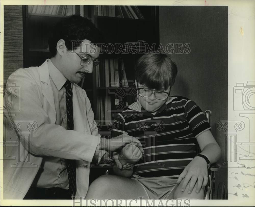 1985 Dr. Allen Gruber, Neurologist checking Clinton Bell,12, Texas-Historic Images