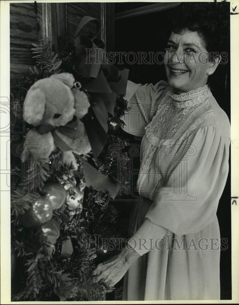 1985 Maggie Hardy hangs Christmas wreath on her Oak Hills front door-Historic Images