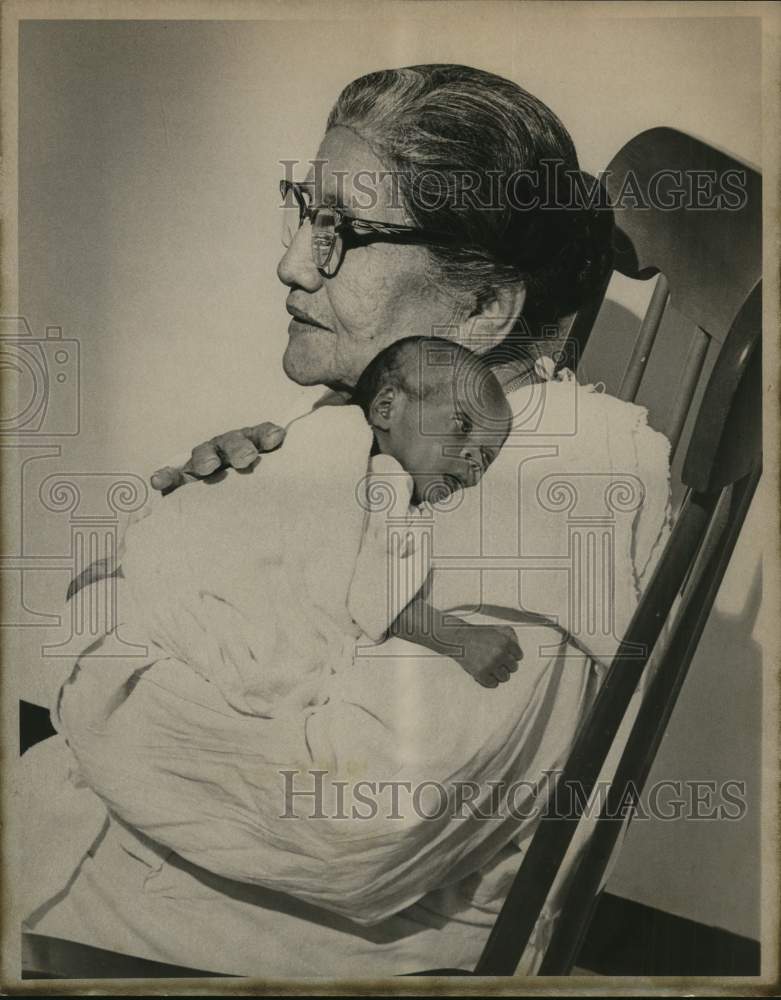 1975 Delores Herrera, 81, holding baby girl of Audre Henry, Texas-Historic Images