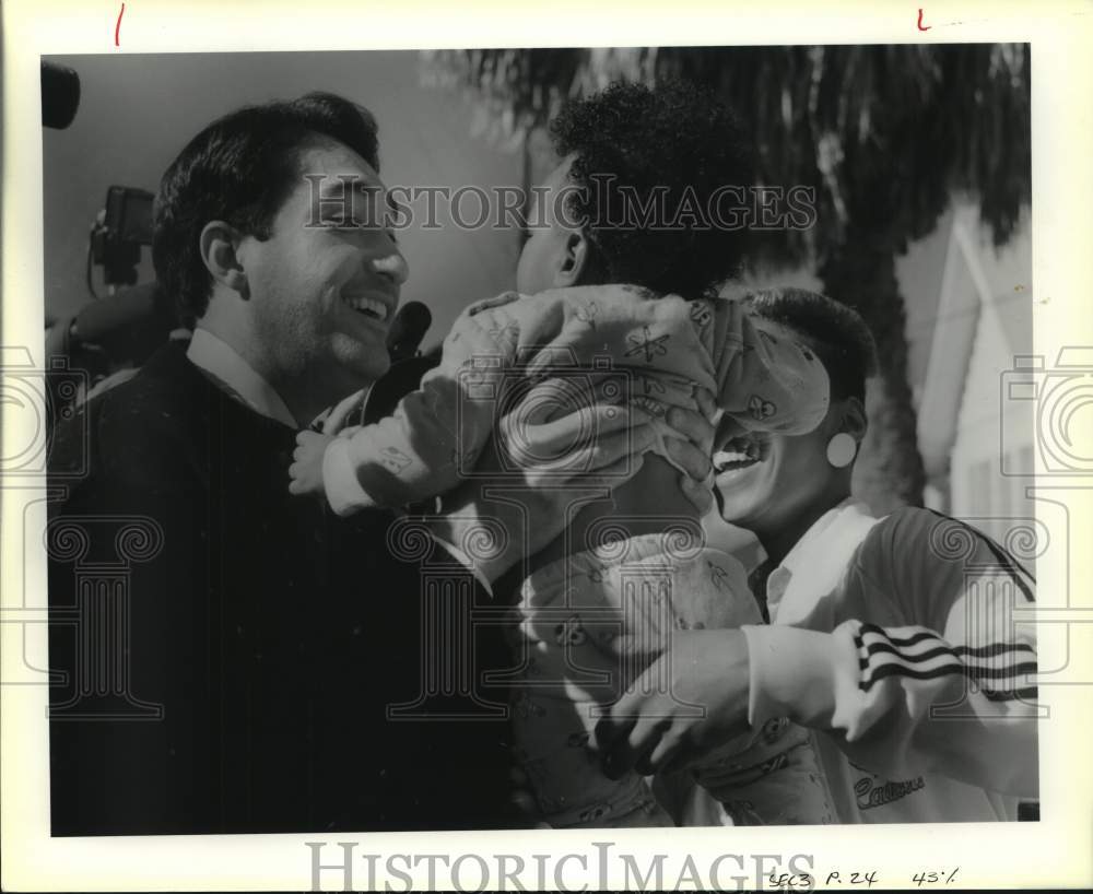 1989 Mayor Henry Cisneros holding baby while campaigning, Texas-Historic Images