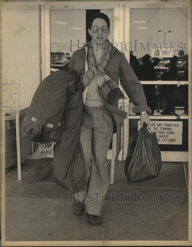 Designer Ronald Kolodzie rushes from airport terminal-Historic Images
