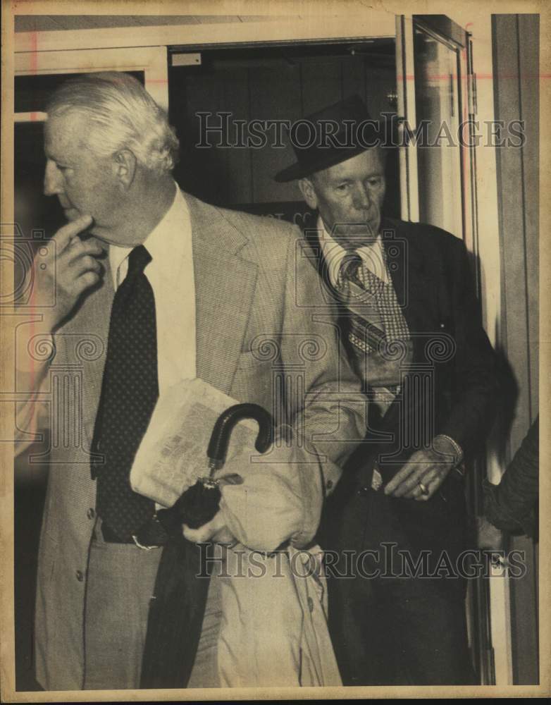 1975 John R. McFarlin, with hat, and Michael Caine leaving building.-Historic Images
