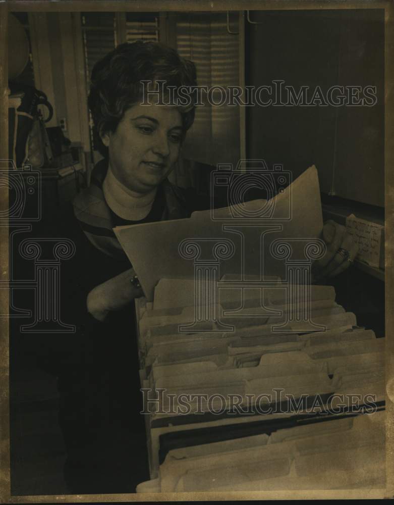 Mrs. Sherwood Inkley, former Bebe Canales looks through files.-Historic Images