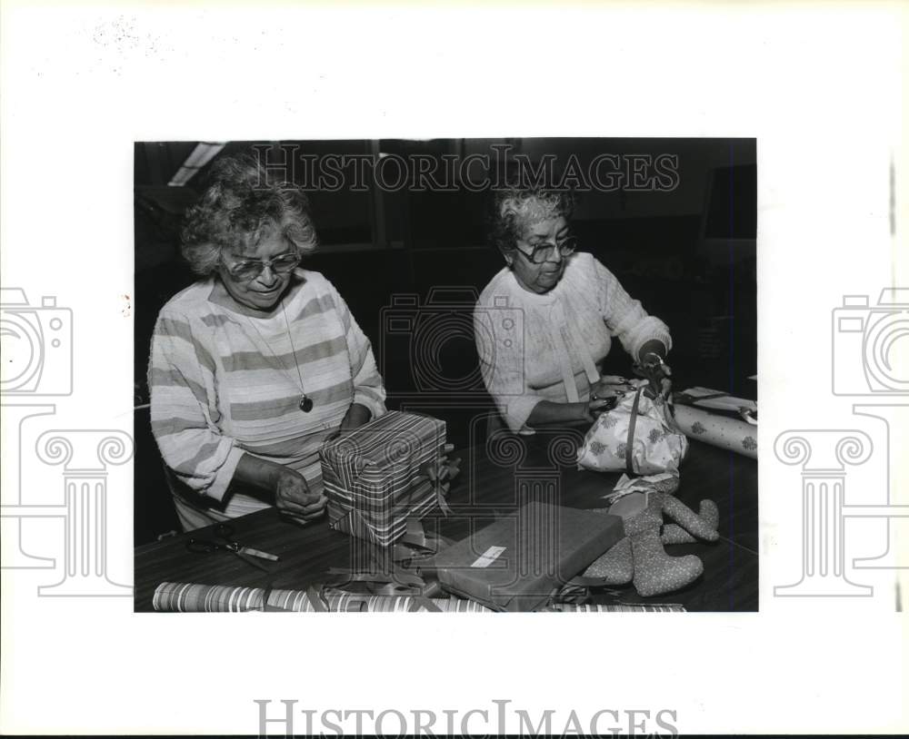 1987 Estelle Luna and Rogelia Hernandez wrap Christmas gifts.-Historic Images