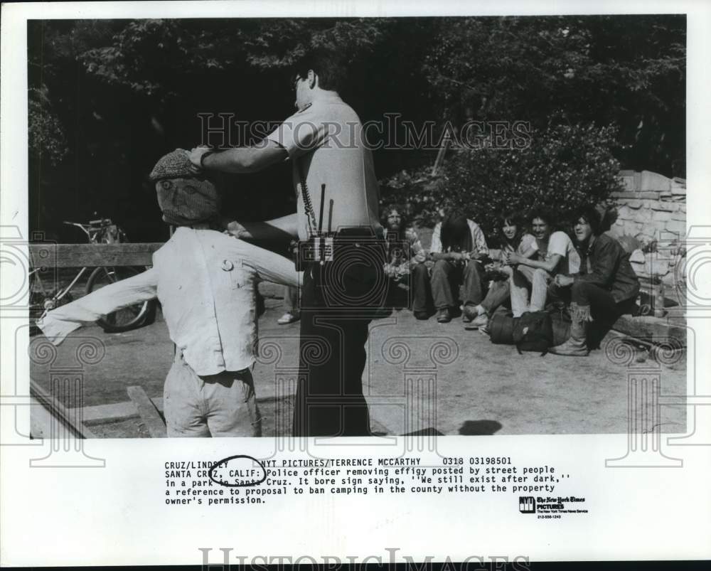 Police officer removing effigy by street people in a Santa Cruz park-Historic Images