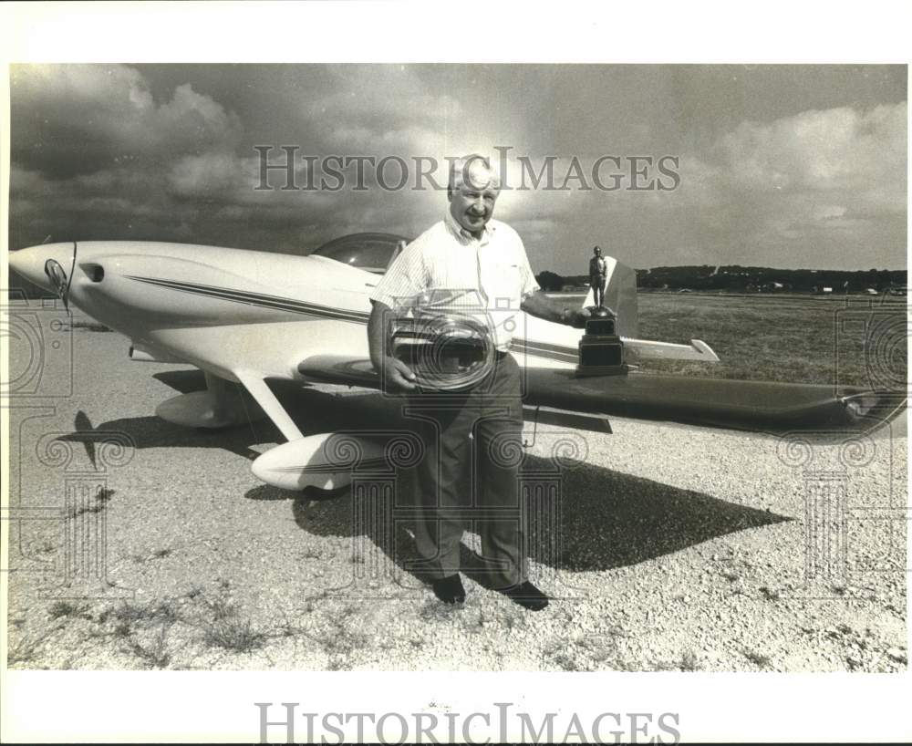 1987 Paul McReynolds next to his plane holding trophies, Texas-Historic Images