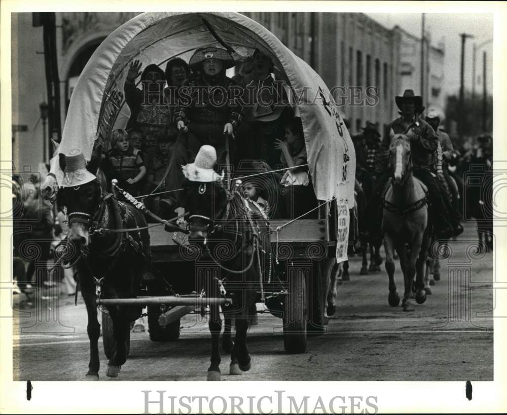 1984 Press Photo Family riding in covered wagon at the Stock Show parade, Texas - Historic Images