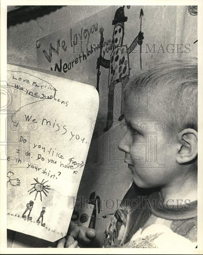 Press Photo Abe Hibdon holding a &quot;We Miss You&quot; note - sab15158- Historic Images