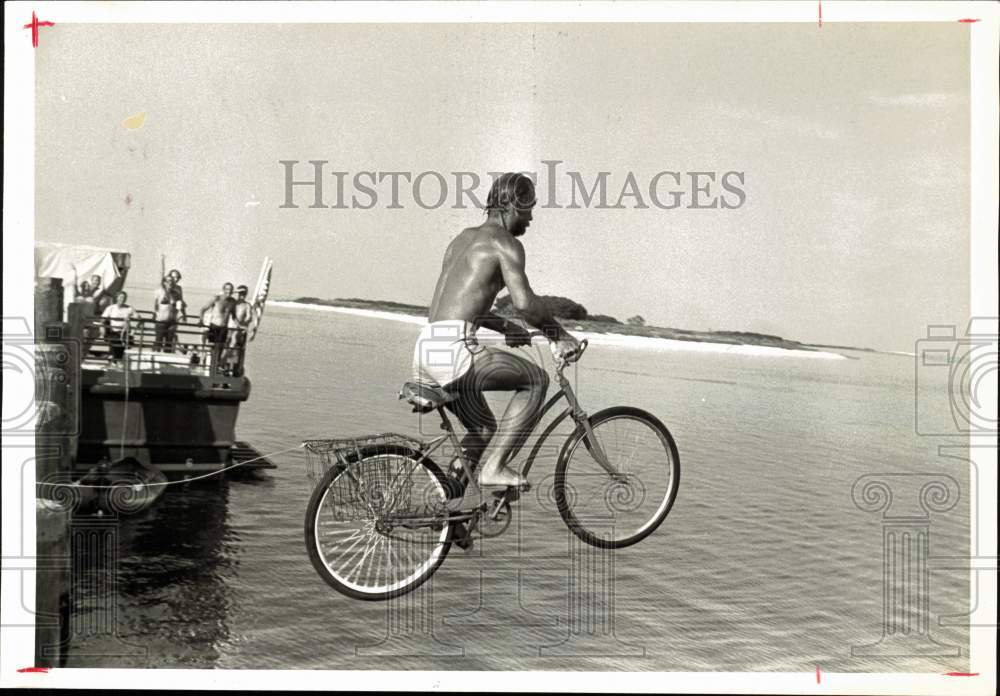 1981 Press Photo Fred Hagstrom rides bicycle off dock at Ft. Jefferson, FL - Historic Images