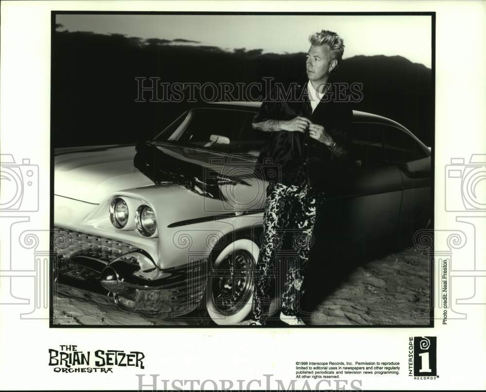 1998 Press Photo Brian Setzer of The Brian Setzer Orchestra beside car on beach- Historic Images