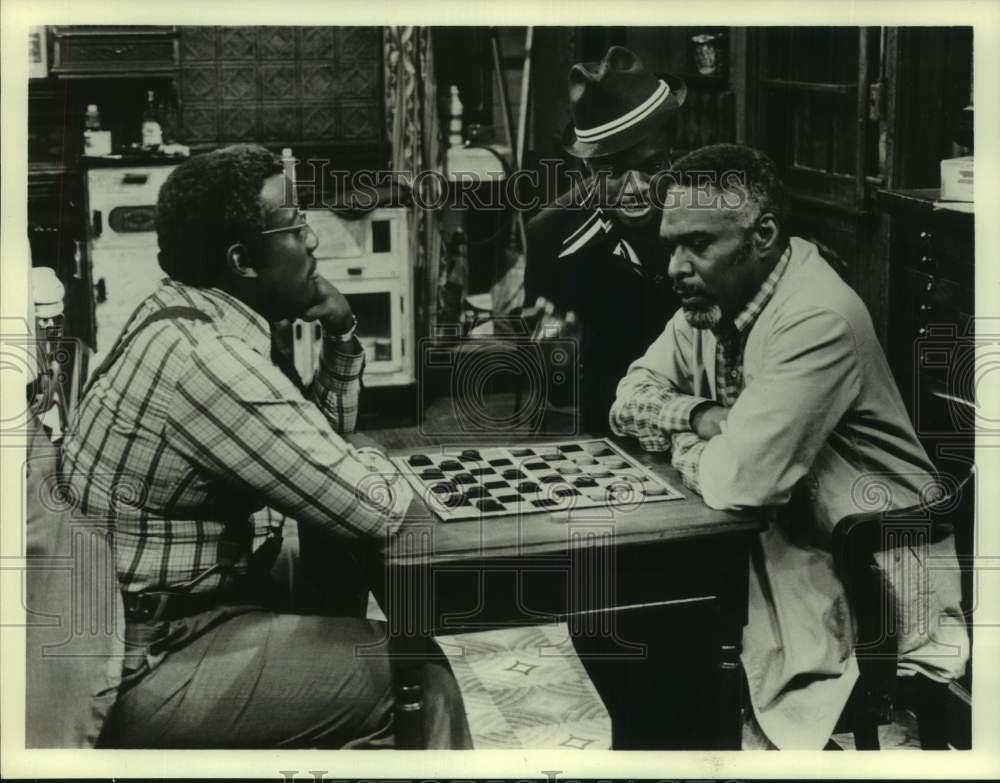 Press Photo Actors play checkers game with co-star in show scene - Historic Images