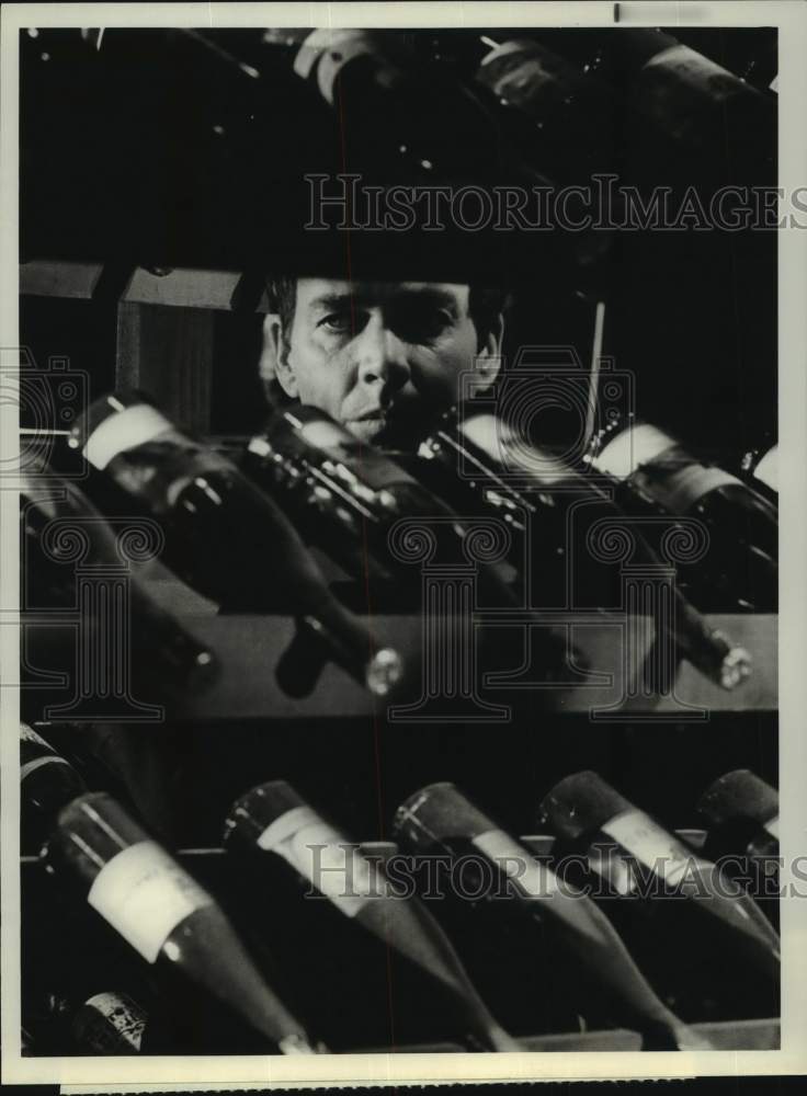 1975 Press Photo Actor Jim Hutton Behind Wine Rack on NBC Series &quot;Ellery Queen&quot; - Historic Images