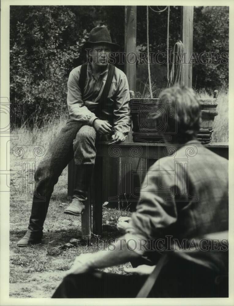 Press Photo Actor Scott Thomas Portrays Pioneer, Sits on Well - Historic Images
