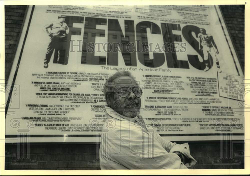 Press Photo A man stands in front of Broadway play poster for Fences. - Historic Images
