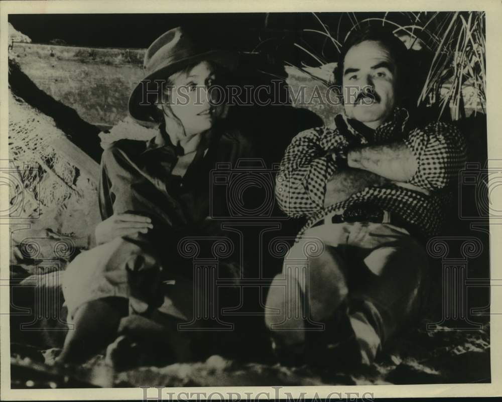 Press Photo Actor Burt Reynolds &amp; Woman Rest on Log in Scene - Historic Images