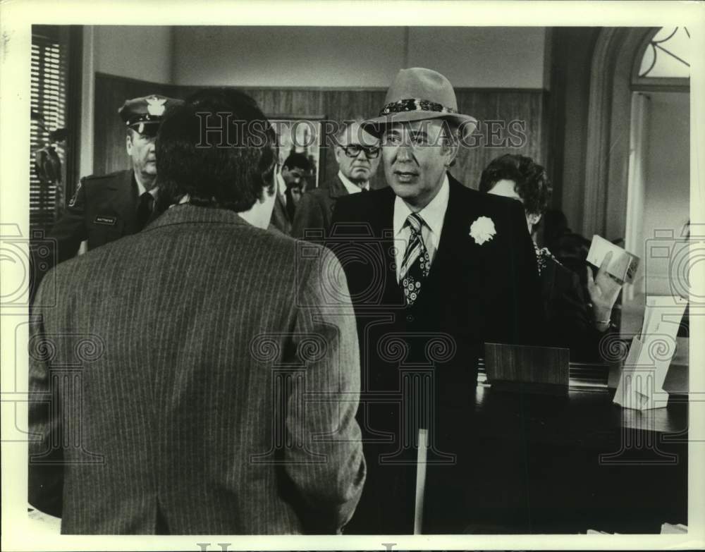 Press Photo Man in Fedora With Cop Confronts Group in Office - Historic Images