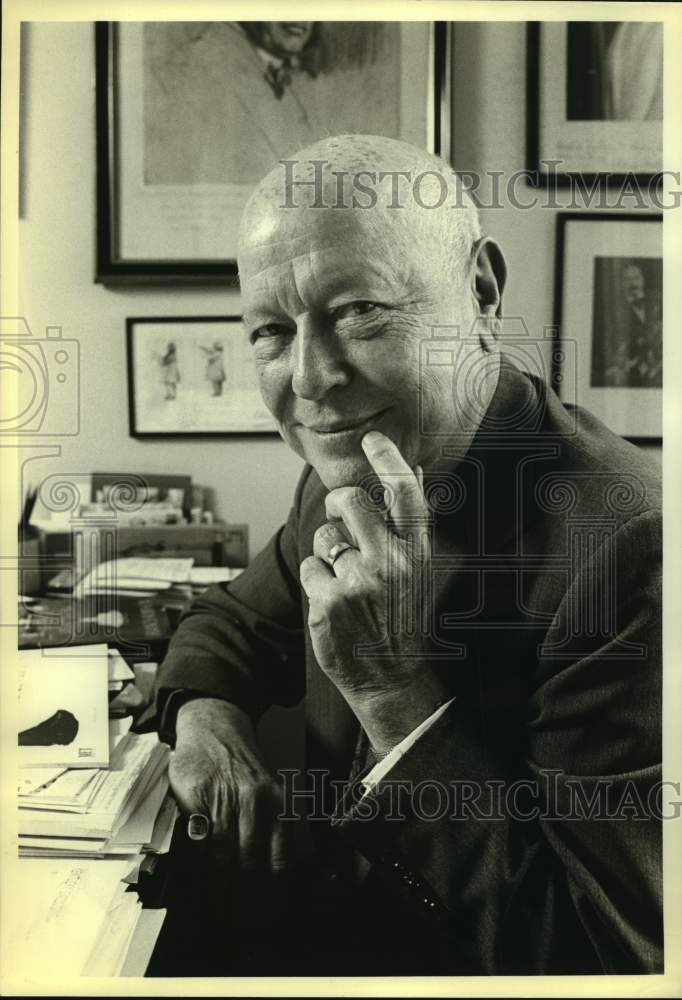 Press Photo Man Sits at Desk with Finger on Chin - Historic Images