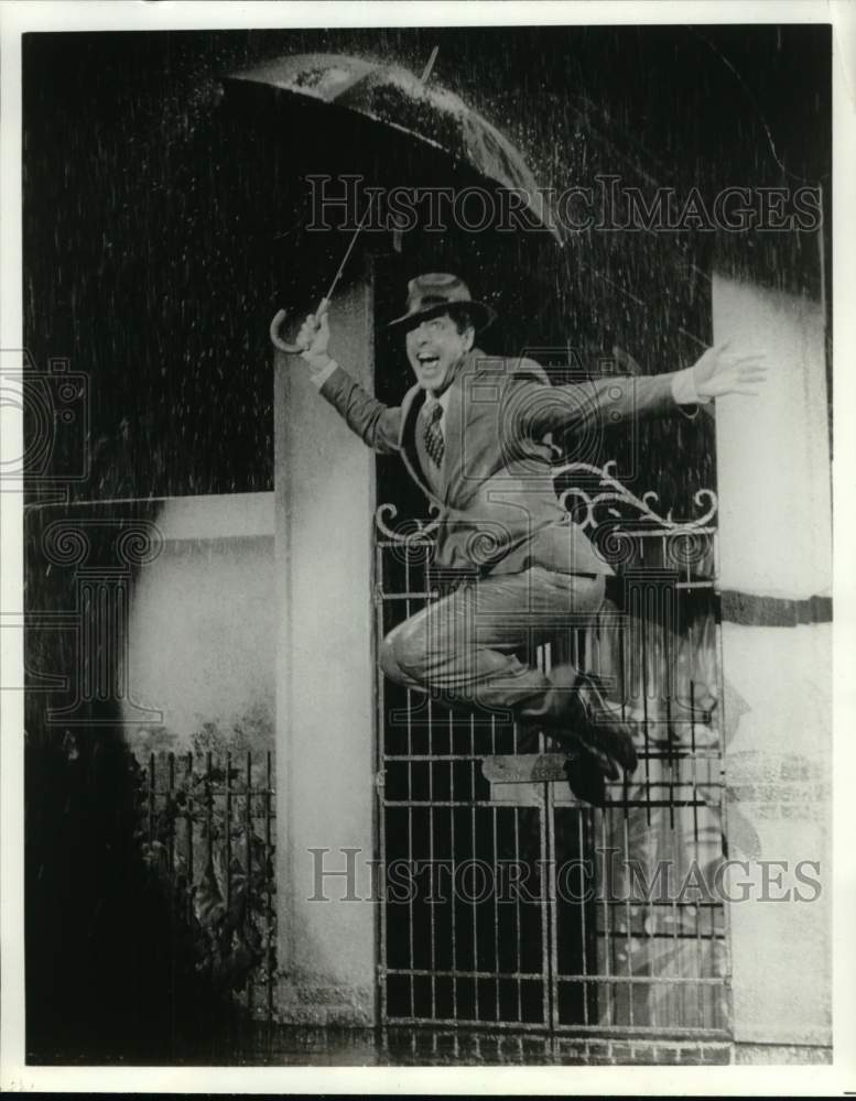 Press Photo Actor Dances in Rain With Umbrella - Historic Images