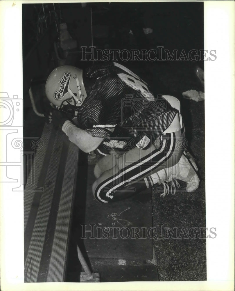 Huskies Football Player Kerry Cash Prays on Bench-Historic Images