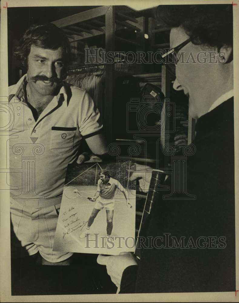 Press Photo Tennis player John Newcombe presents an autographed photo - Historic Images