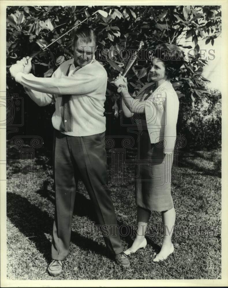 Press Photo Walter Corrigan and woman with golf clubs - sas18574 - Historic Images