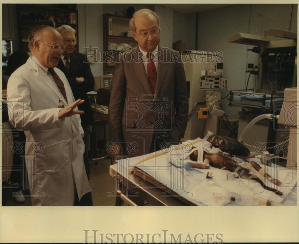 1988 Press Photo Dr. Robert A. Delemos Shows Senator Phil Gramm a Baby Baboon - Historic Images