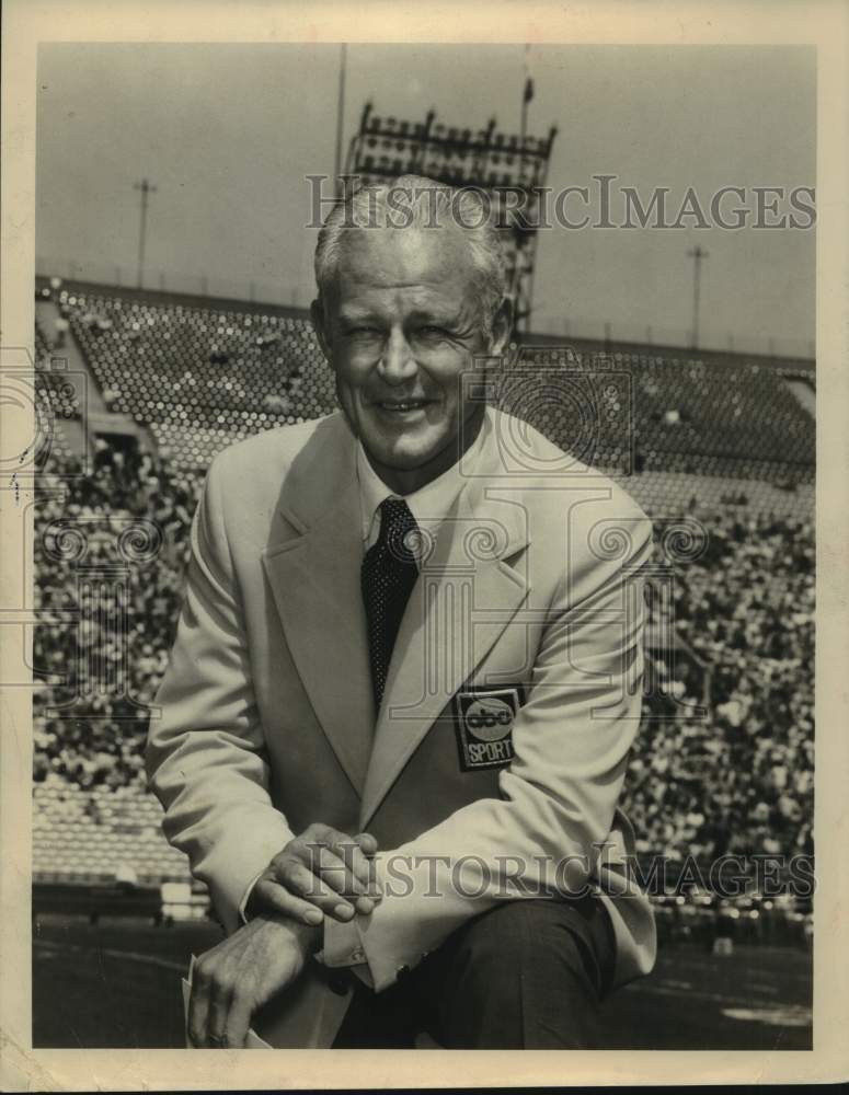 Press Photo ABC Sports Anchor Bud Wilkinson Kneels on Football Field - sas21677 - Historic Images