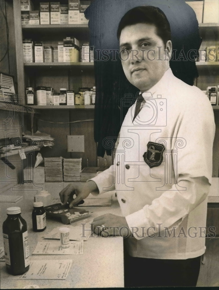 Press Photo Druggist, Richard Teniente in front of the medicines - Historic Images