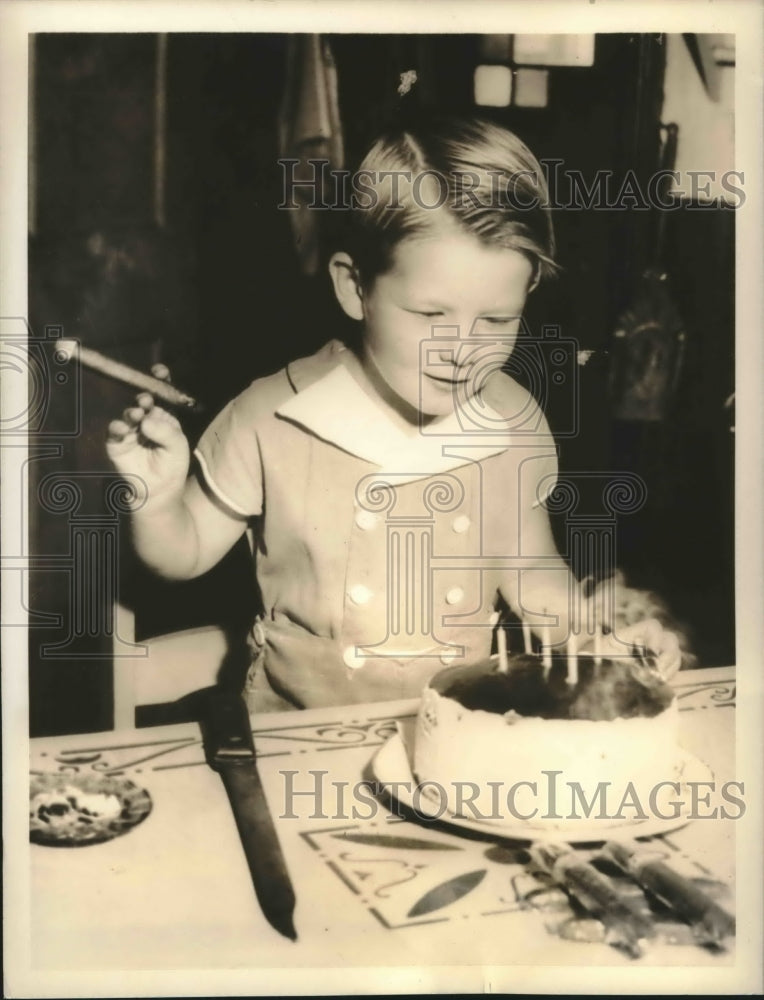 1936 5 year old Mickey Norman lights candles on birthday cake - Historic Images
