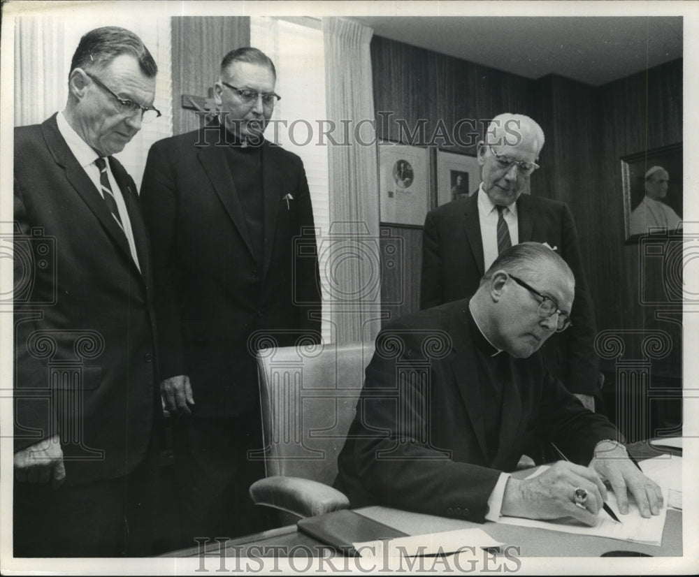 Press Photo Archbishop Furey shown as he signs papars - Historic Images