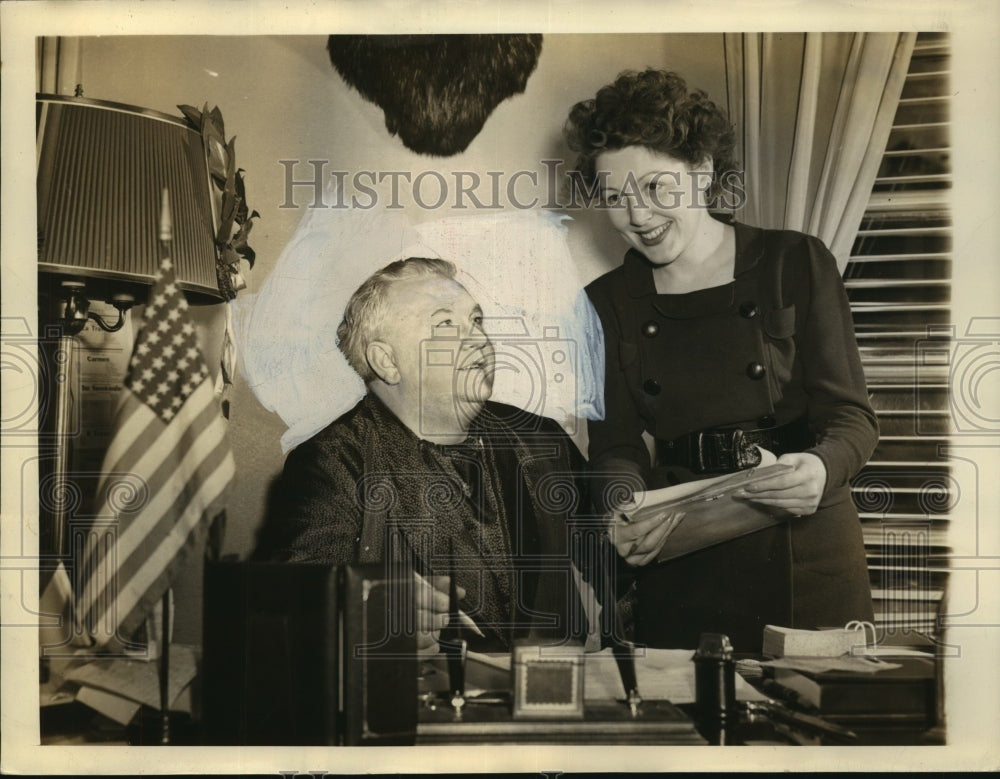 1943 Lauritz Melchior and wife behind his ornate mahogany desk - Historic Images